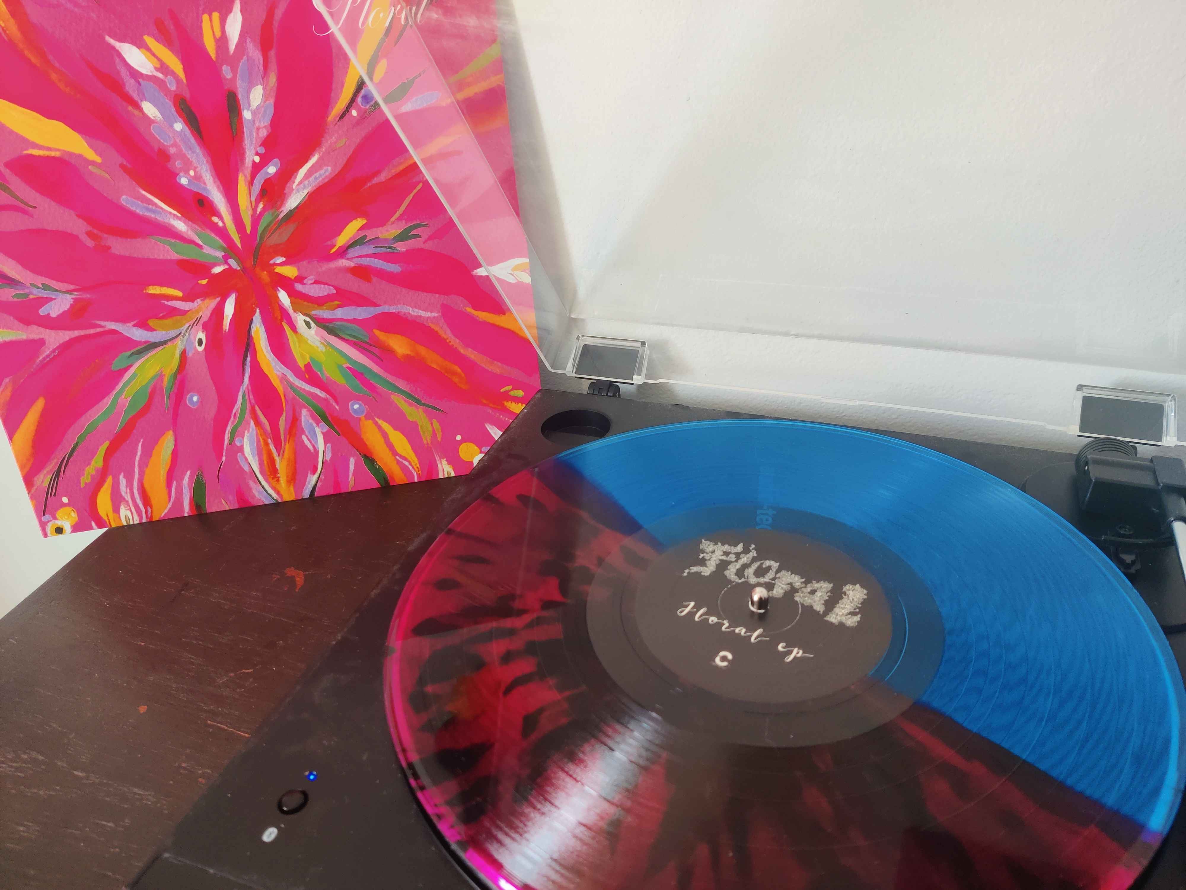 Photo of the record on a turntable beside the album jacket.